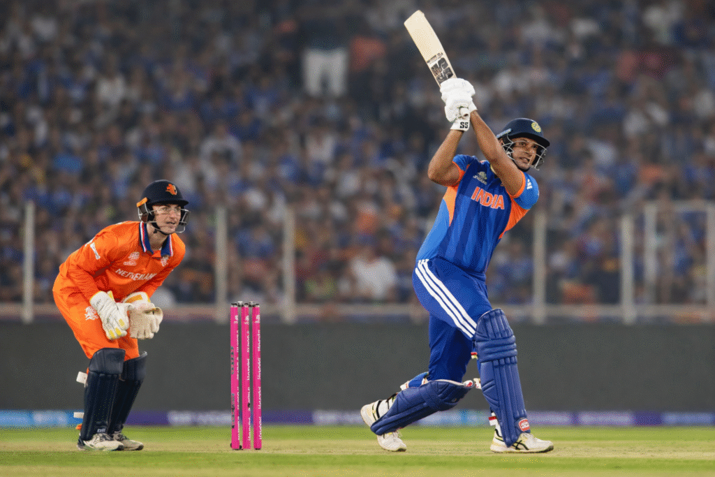 India vs Netherlands cricket match 2026 showing an Indian batsman playing an attacking shot while Netherlands wicketkeeper watches behind the stumps